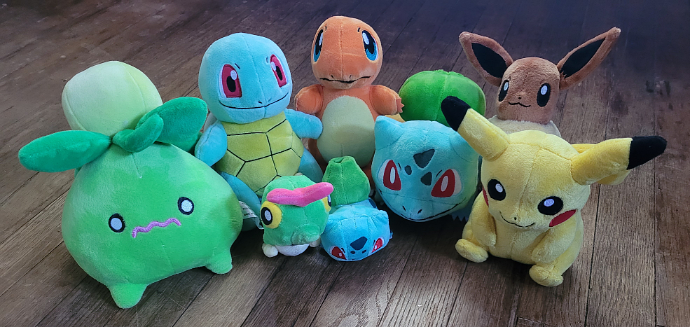 A handful of Pokemon plushies. The Kanto starters, Pikachu and Eevee, Smolliv, and a smaller Bulbasaur and Caterpie.